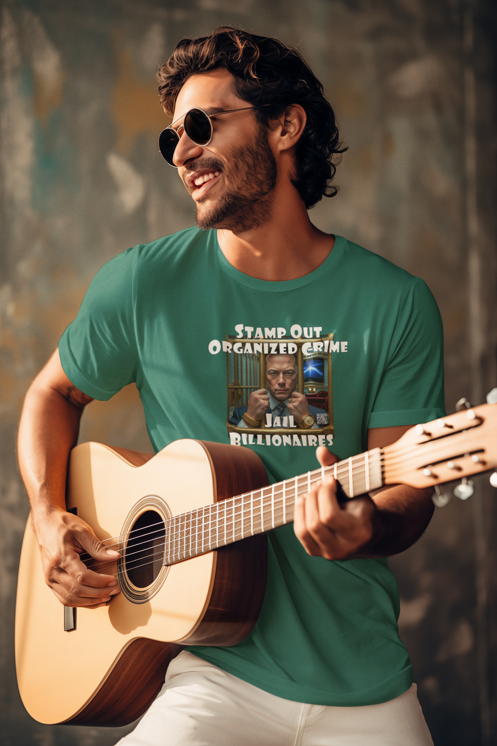 Man smiling while playing guitar in a Stamp Out Organized Crime-Jail Billionaires Activist T-shirt.
