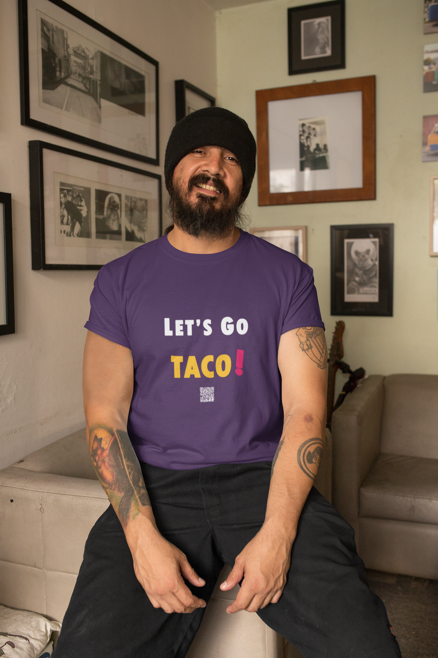 Man wearing a purple TACO Activist TShirt with text 'LET'S GO TACO!' in a stylish setting.