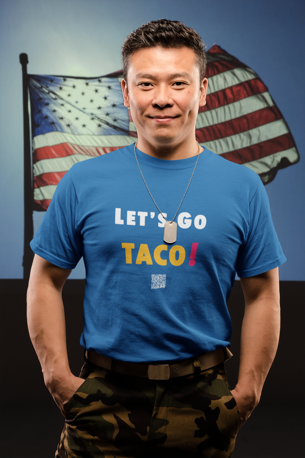 Man wearing a blue TACO Activist TShirt in front of an American flag, promoting a political message.