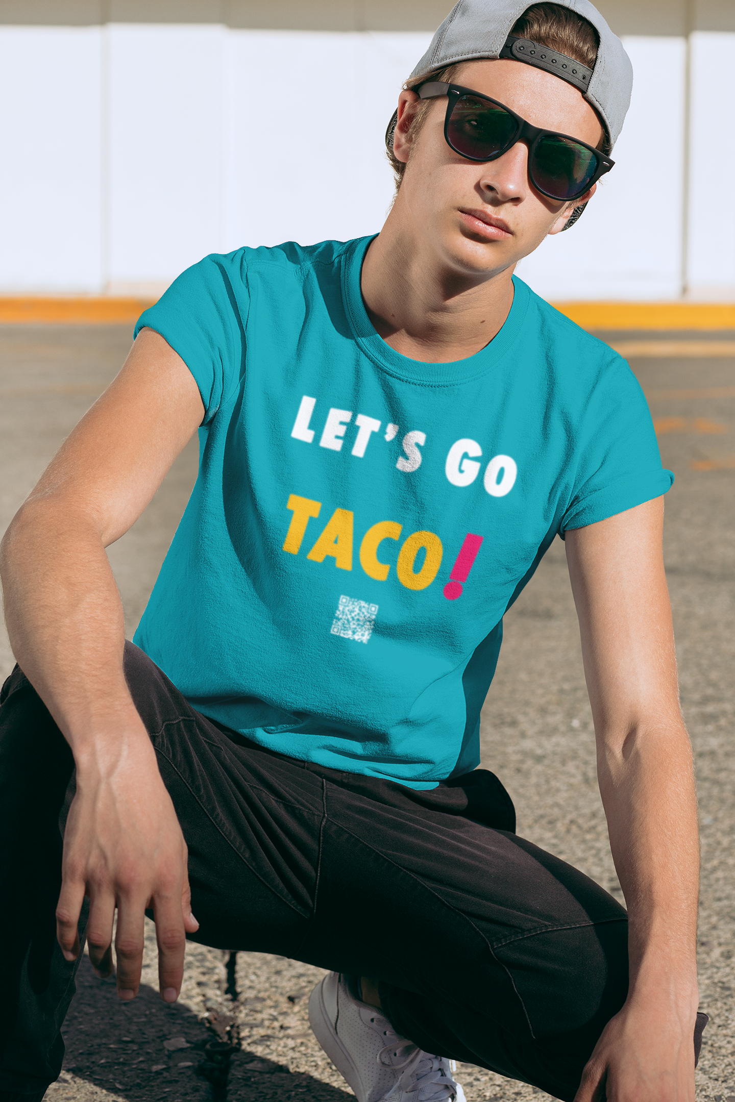 Young person wearing a TACO Activist TShirt with colorful text, promoting the phrase 'Let's Go TACO!' in a casual outdoor setting.