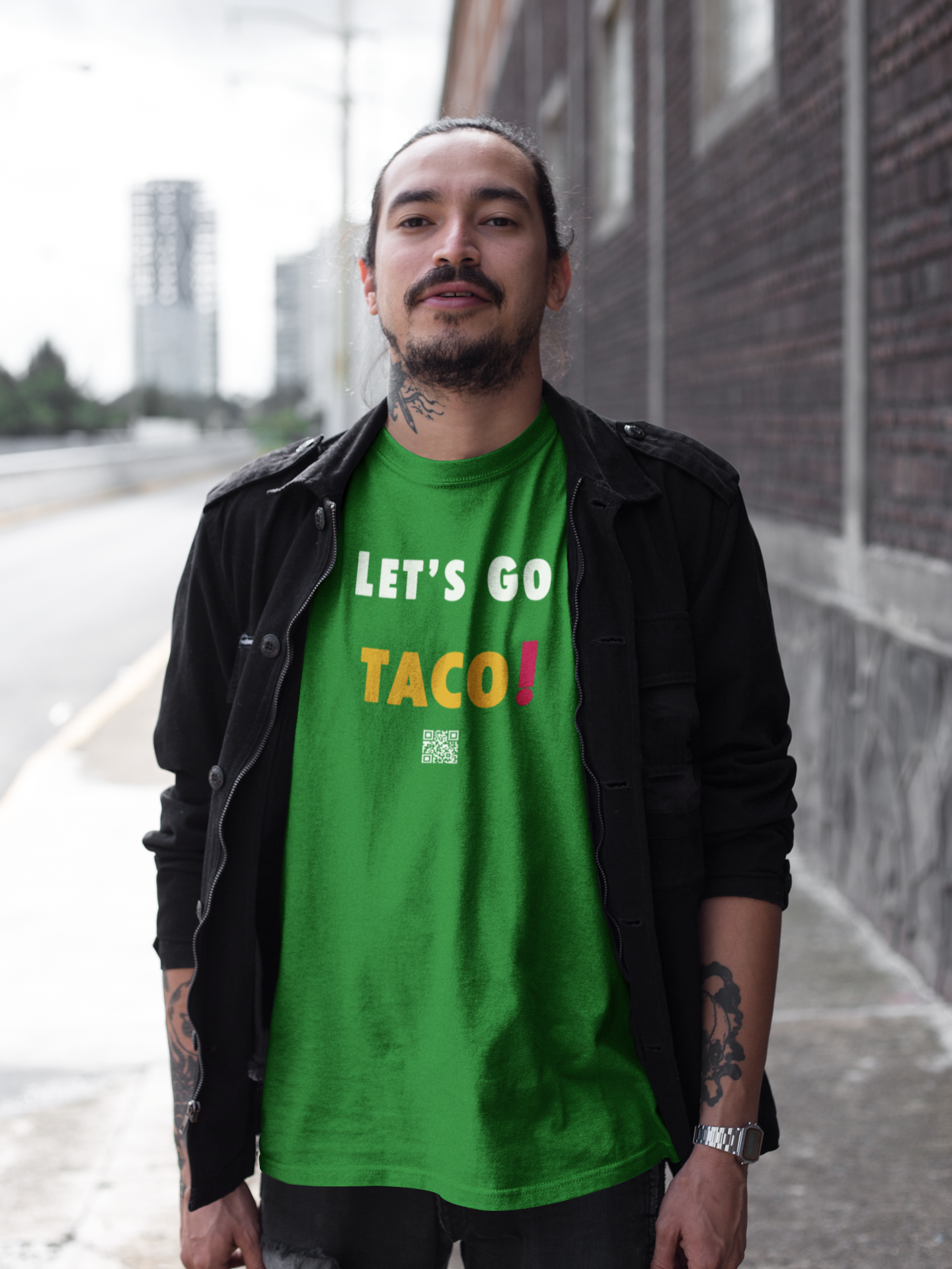 Man wearing a green TACO Activist TShirt with the phrase 'LET'S GO TACO!' printed on it.