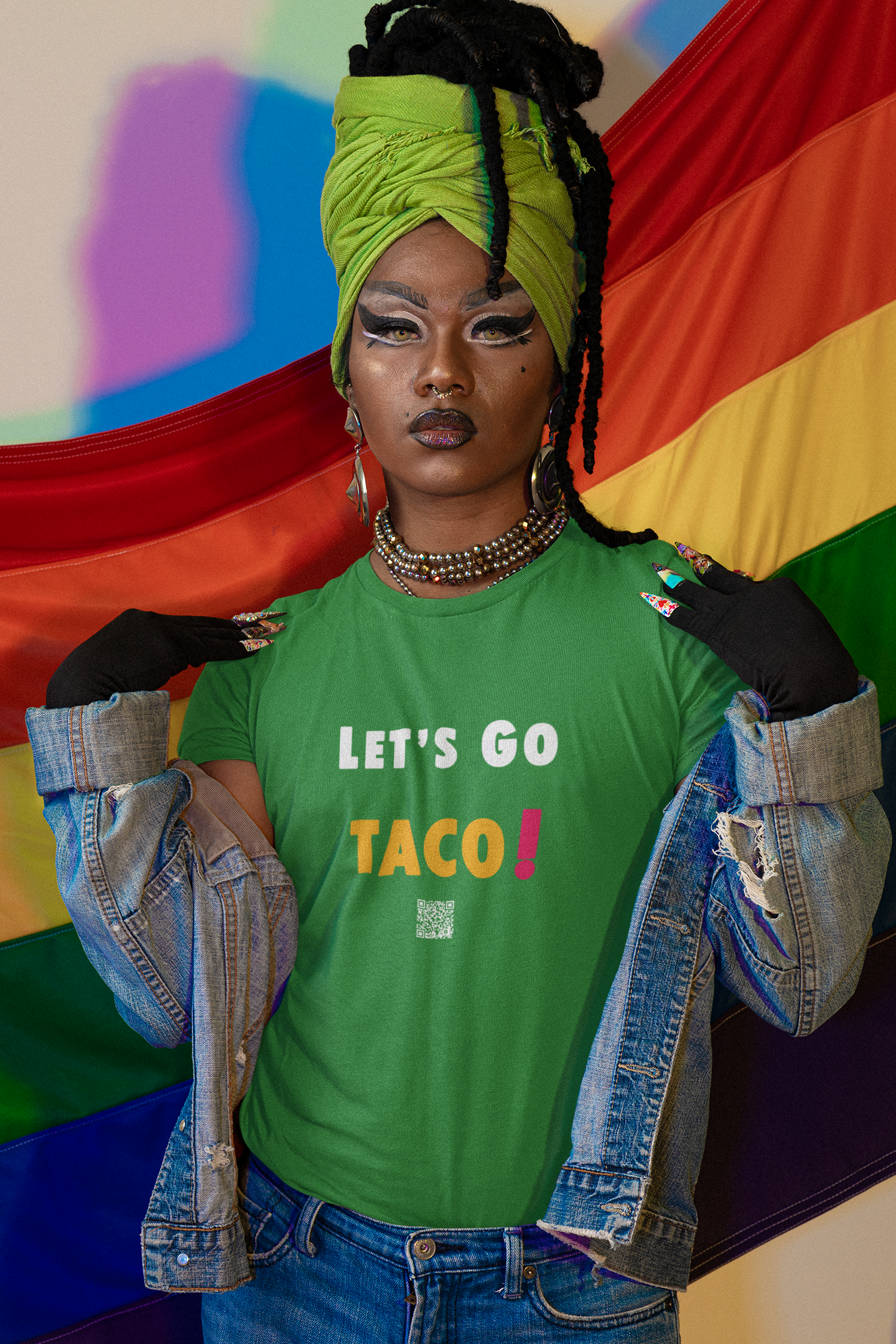 TACO Activist TShirt worn by a person with a vibrant head wrap and rainbow backdrop, promoting inclusivity.
