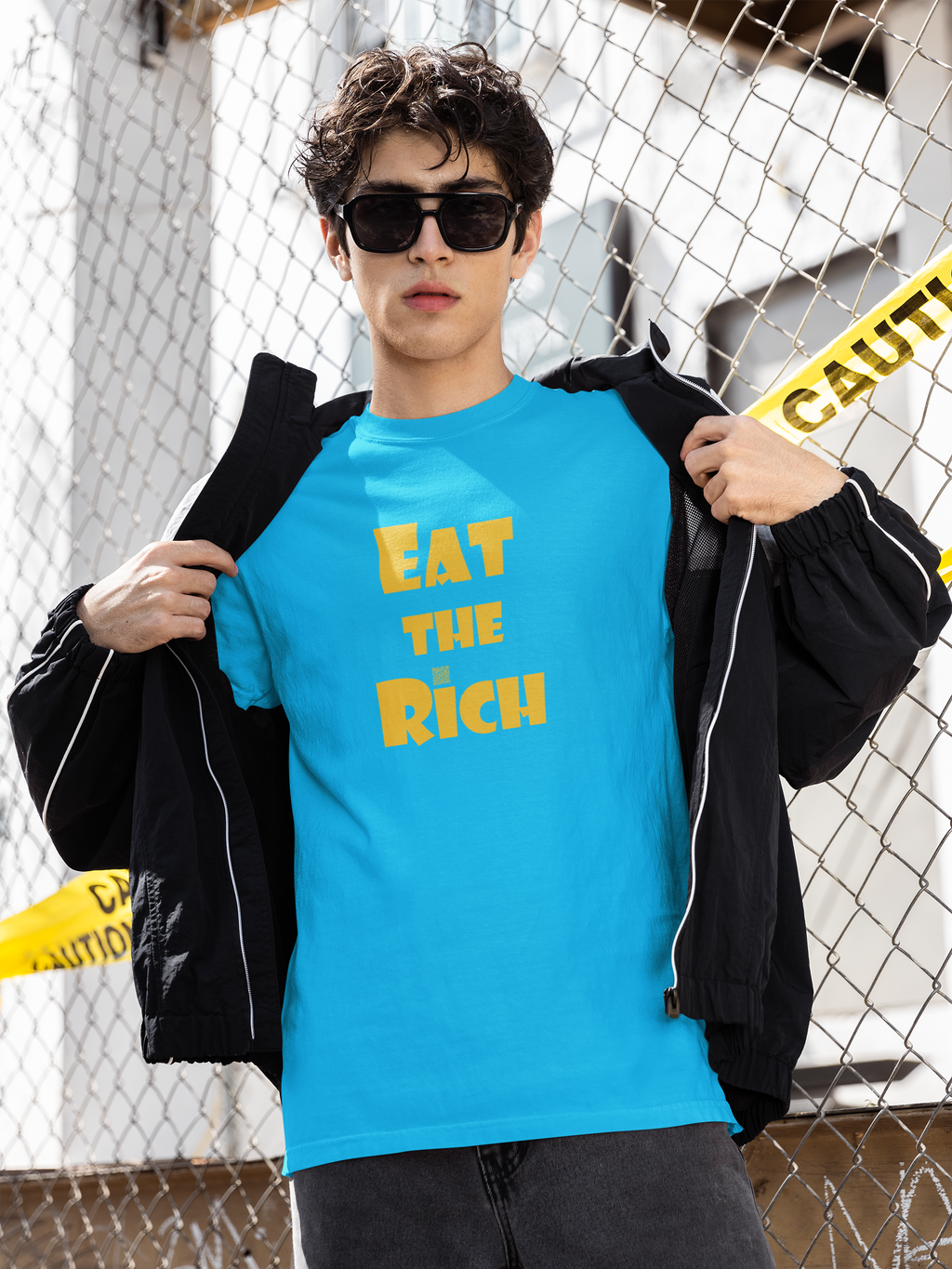 EAT THE RICH Unisex TShirt worn by a model, showcasing bold yellow print on a bright blue background.