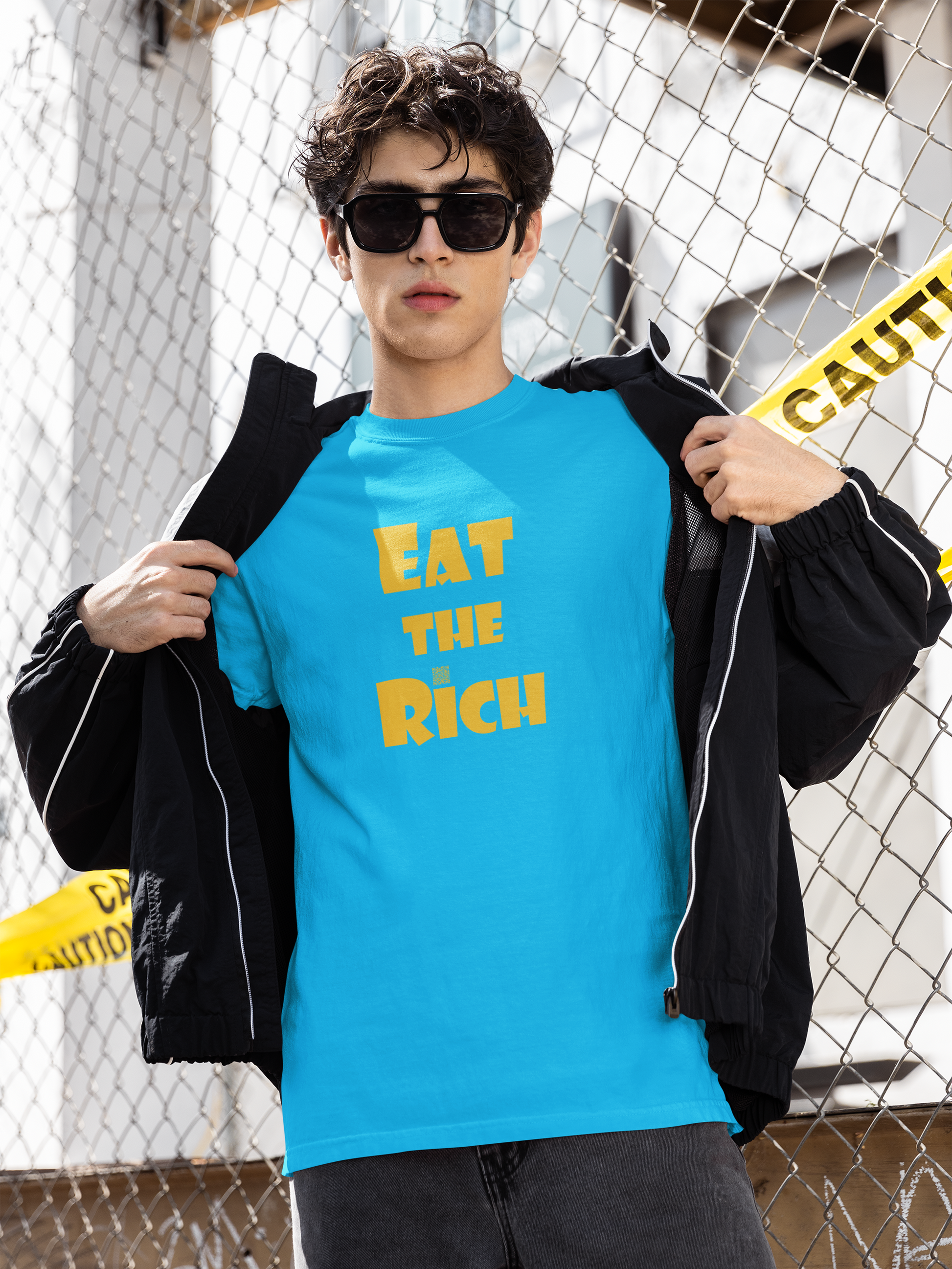 EAT THE RICH Unisex TShirt worn by a model, showcasing bold yellow print on a bright blue background.