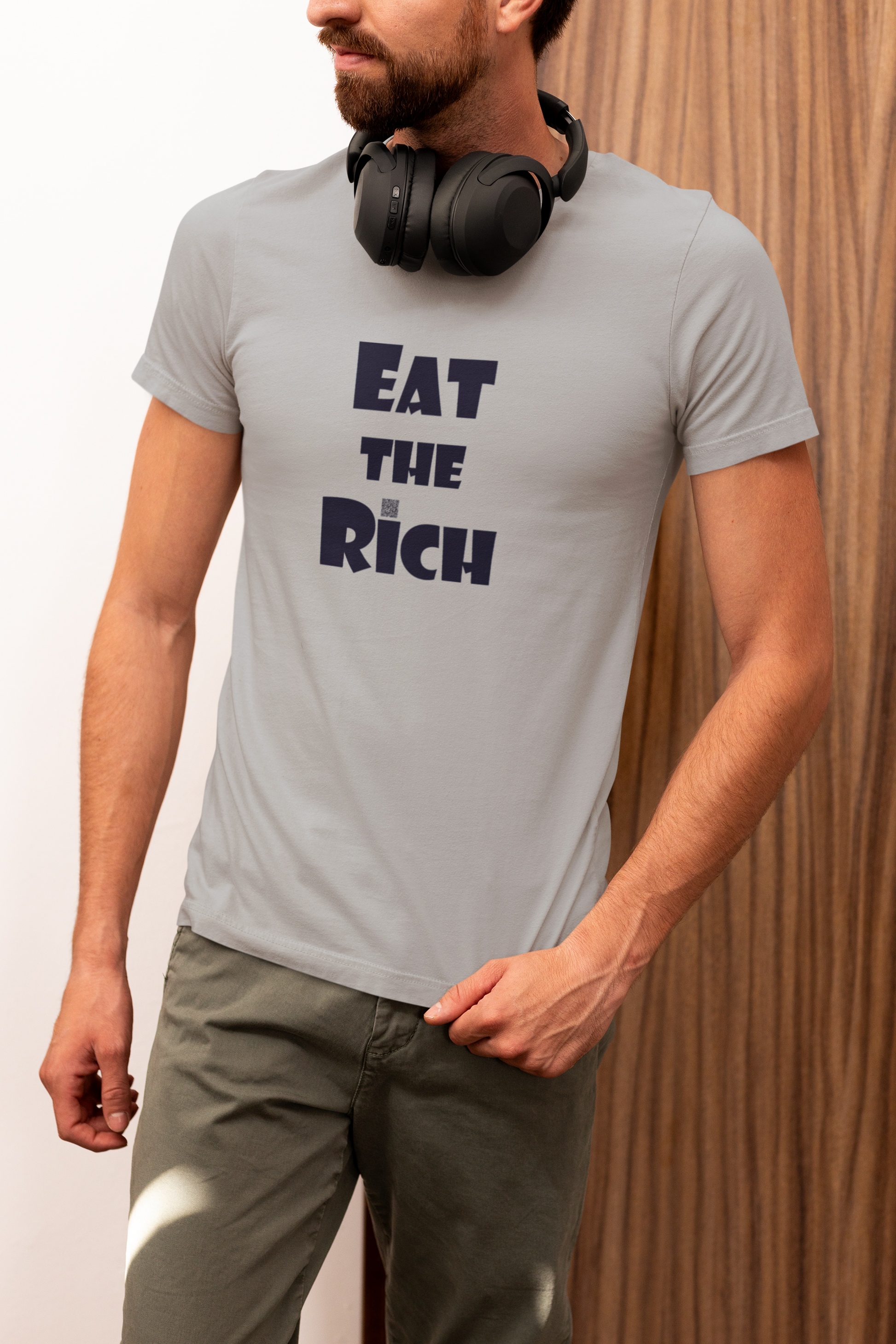 Model wearing EAT THE RICH Unisex TShirt in light grey with bold text design, showcasing a contemporary style.