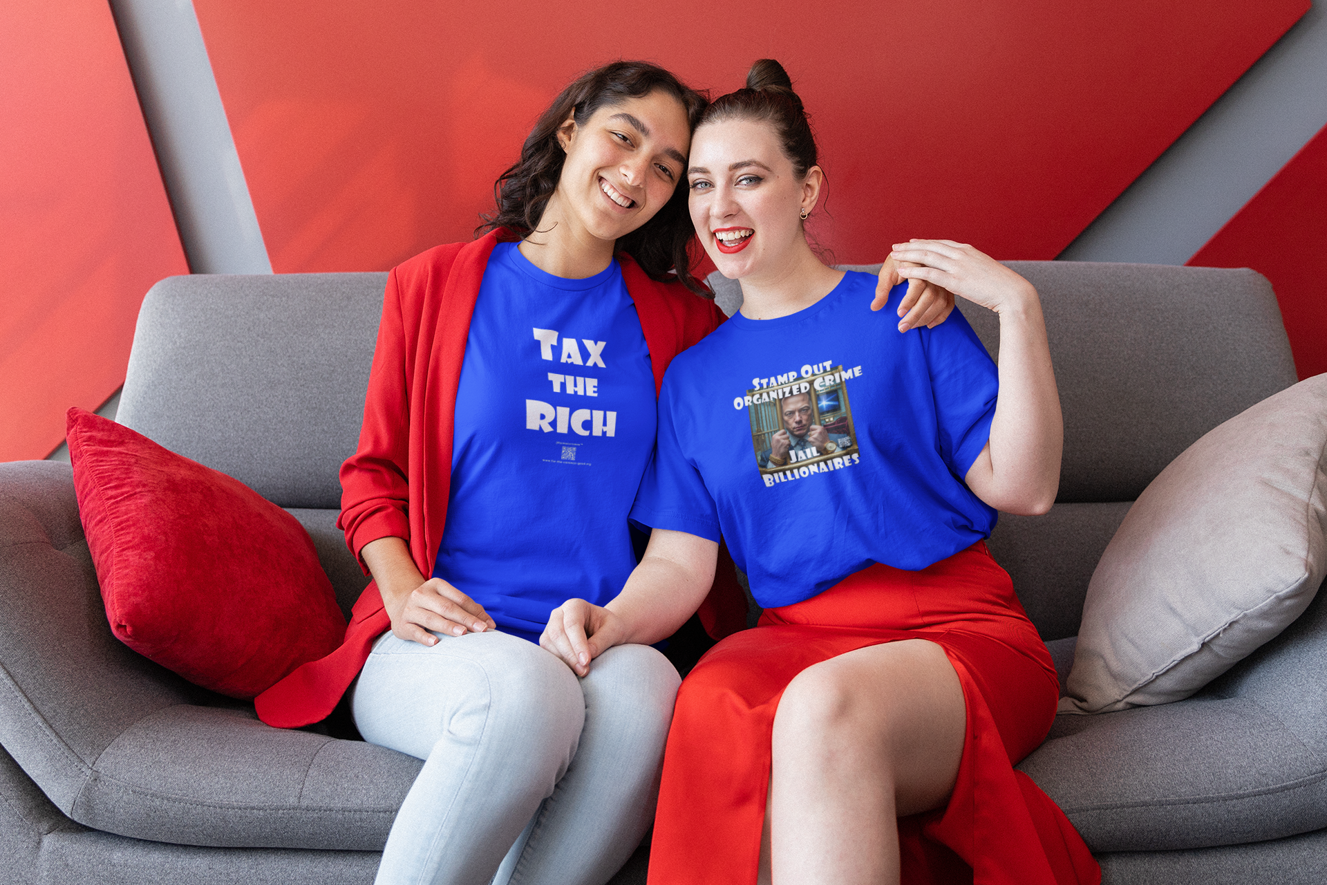 Two women wearing colorful outfits showcase the TAX THE RICH Unisex T-Shirt while sitting on a couch.