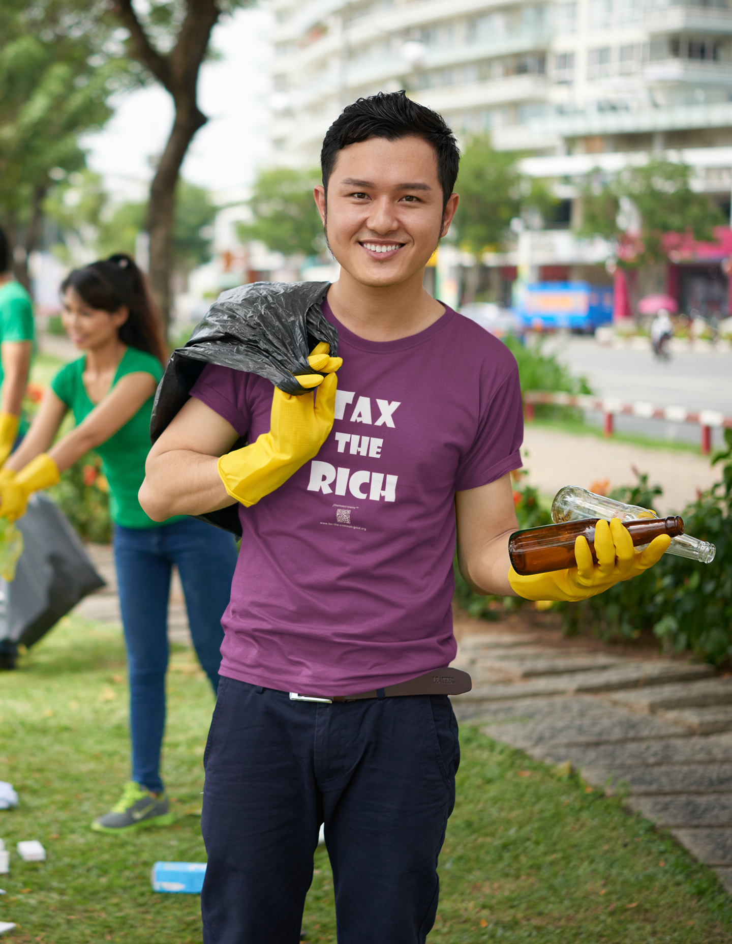 Person wearing TAX THE RICH Unisex T-Shirt while cleaning up litter outdoors.