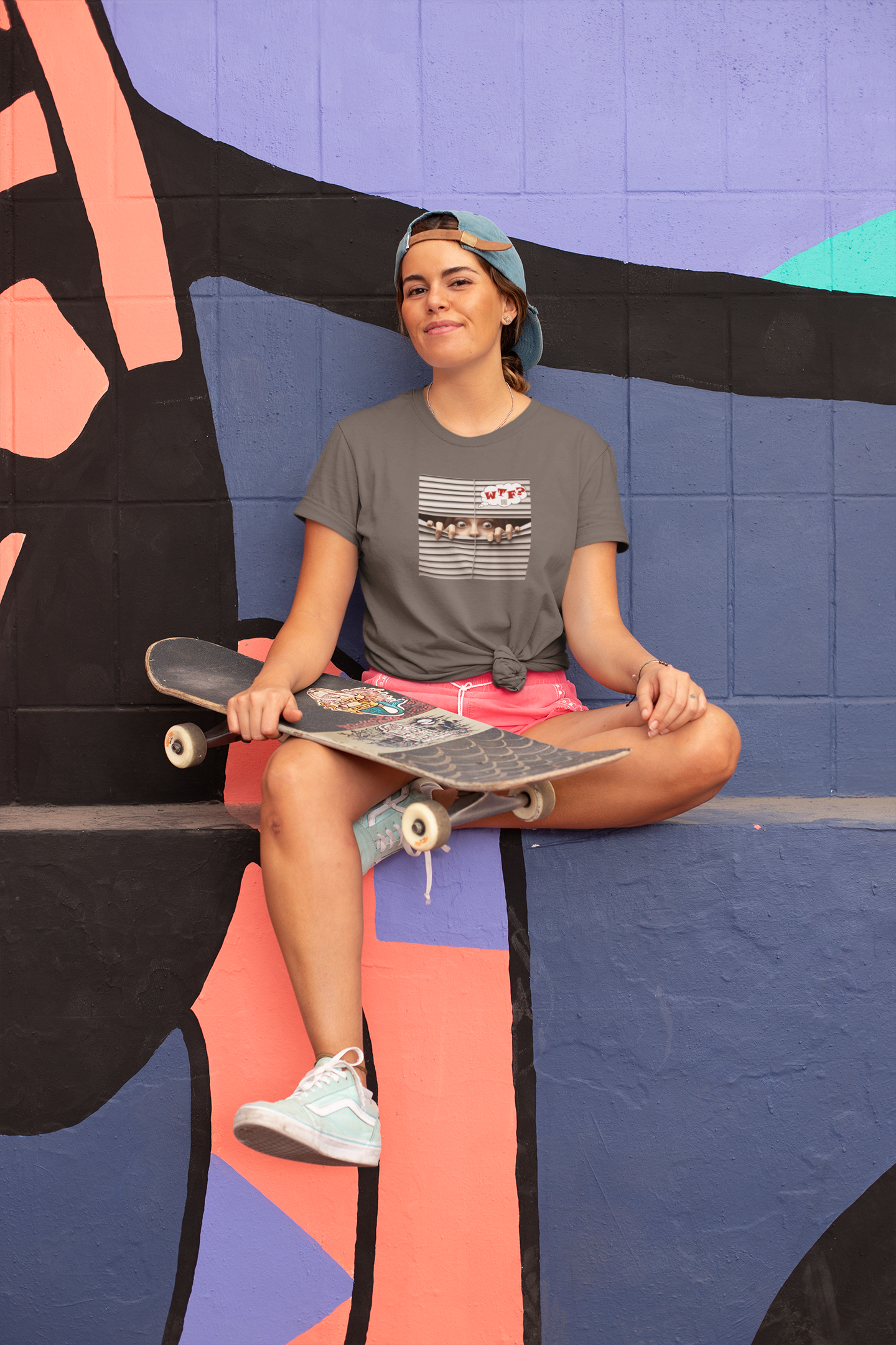 WTF White Female Model Activist TShirt worn by a woman sitting with a skateboard against a colorful mural.
