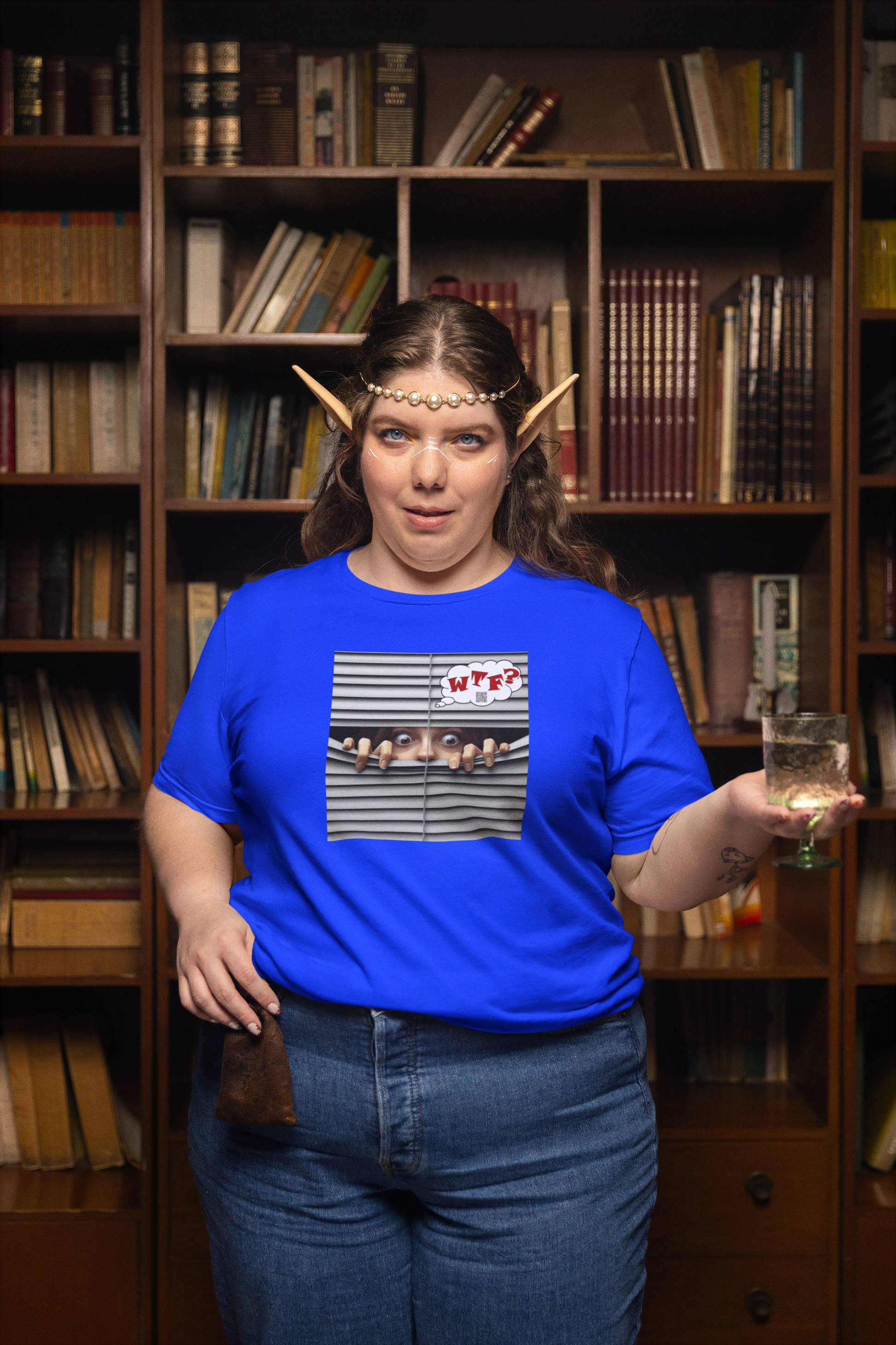 WTF White Female Model Activist TShirt worn by a model holding a drink, standing in front of a library shelf.