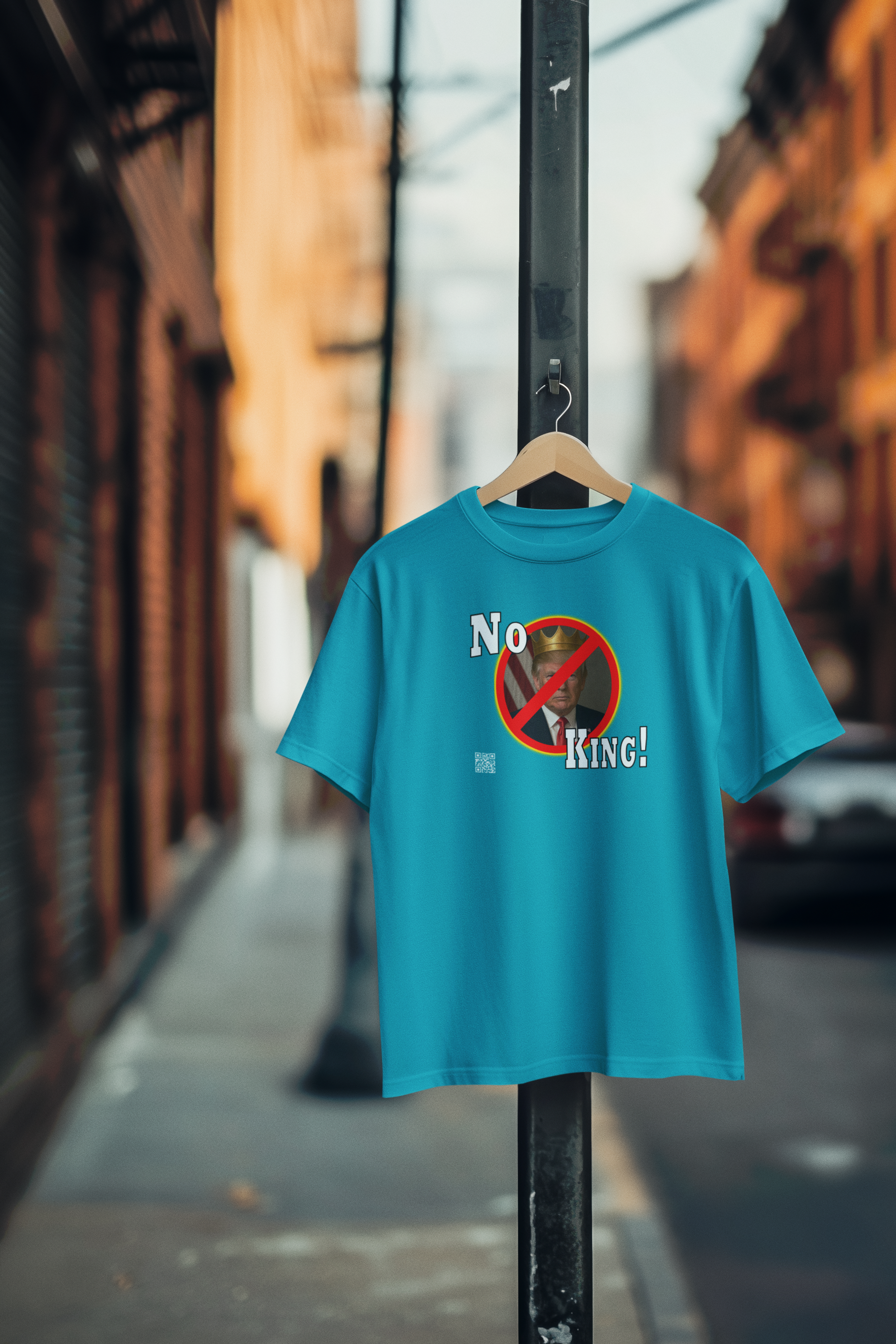 No King Activist TShirt displayed on a hanger outdoors, promoting democratic values and activism.