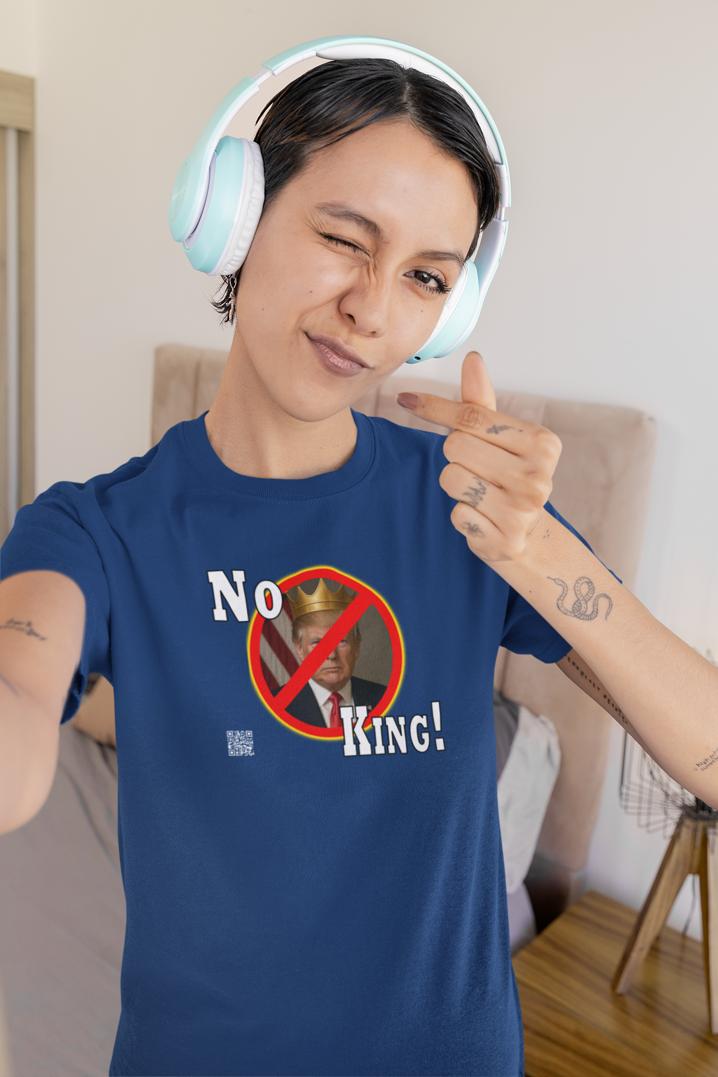 Person wearing a No King Activist TShirt with headphones, showing a confident pose.