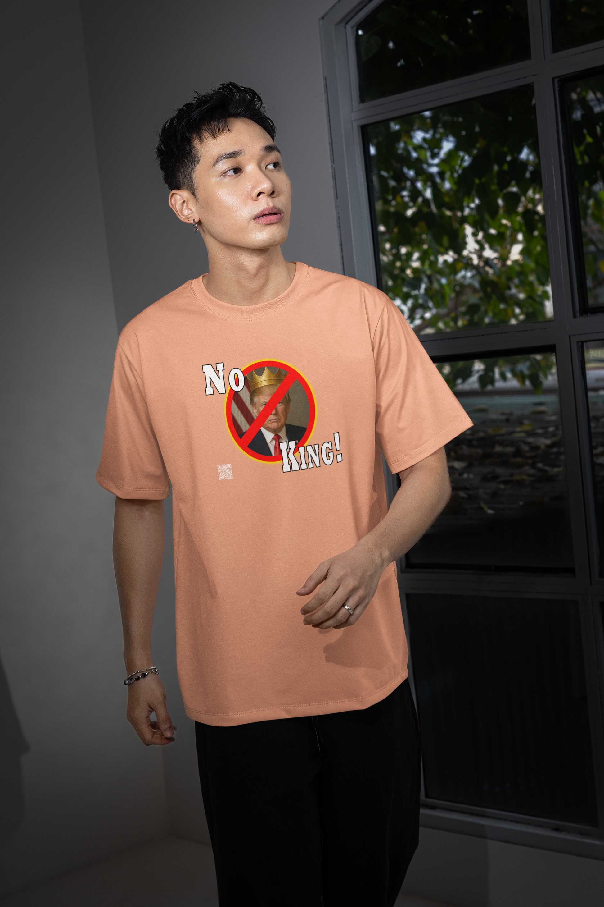 Model wearing No King Activist TShirt, showcasing a bold design against hereditary power.