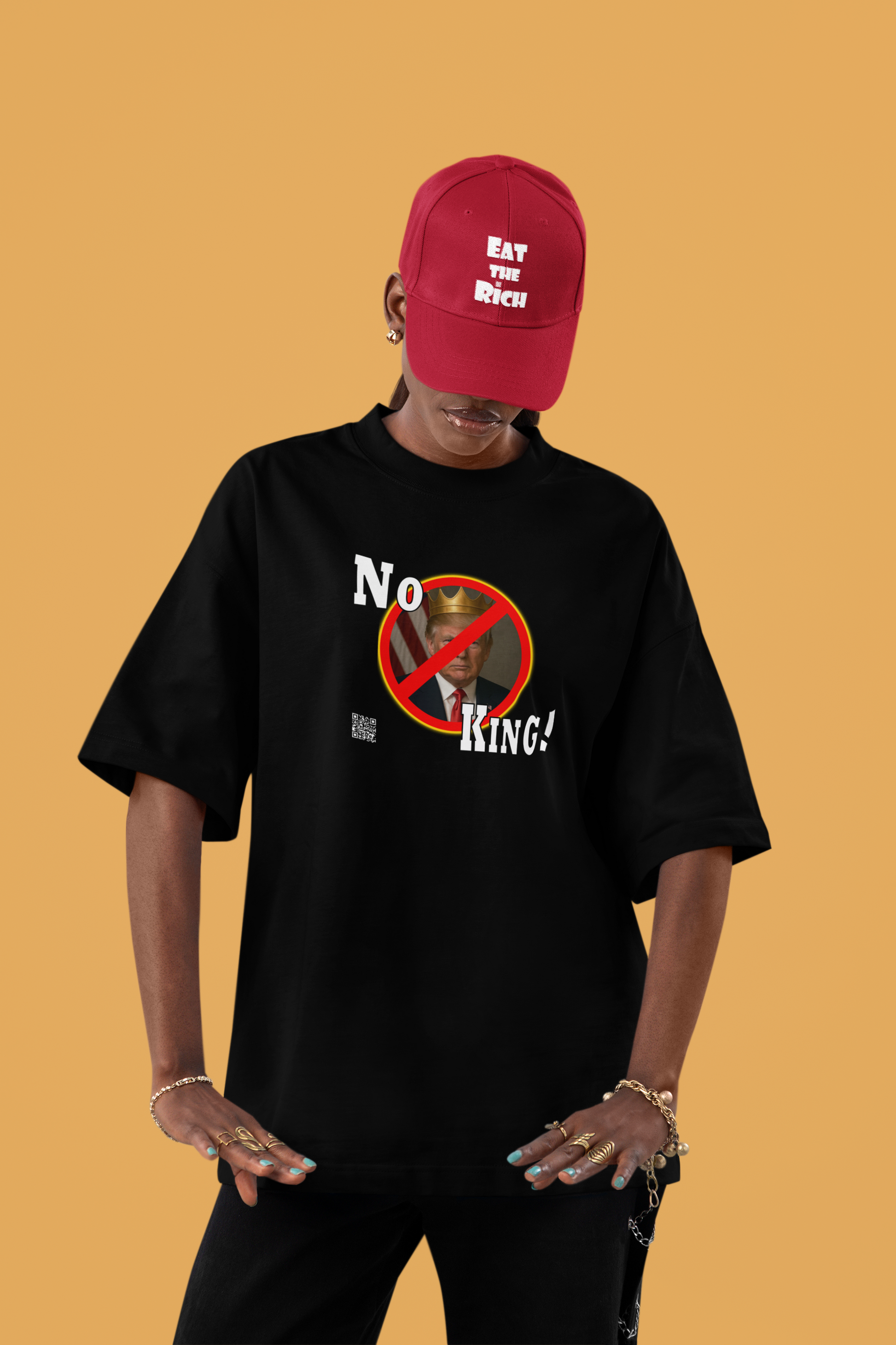 No King Activist TShirt worn by a model with a red cap on a yellow background.