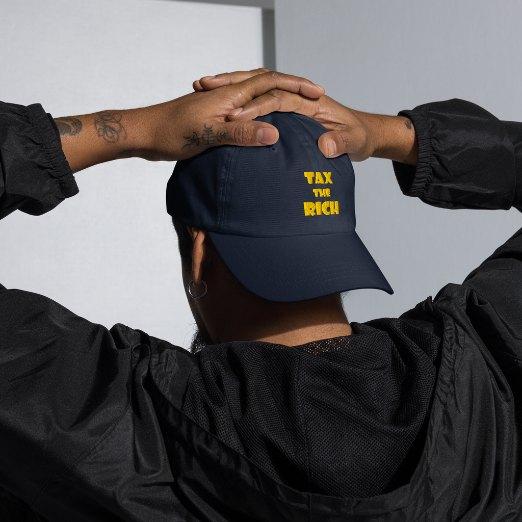 Person wearing a TAX THE RICH — Embroidered Dad Hat with hands behind head.