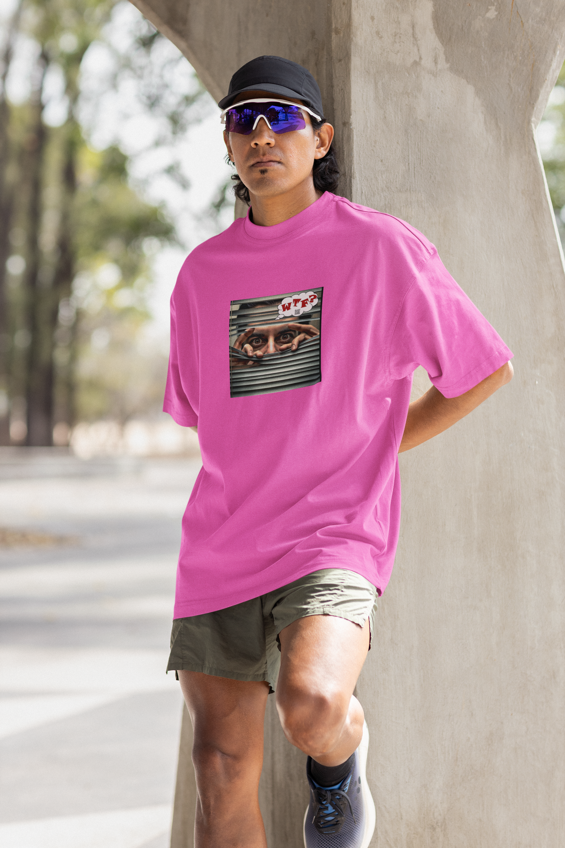 WTF activist t-shirt Hispanic male model wearing a pink shirt with a graphic design, posing outdoors.