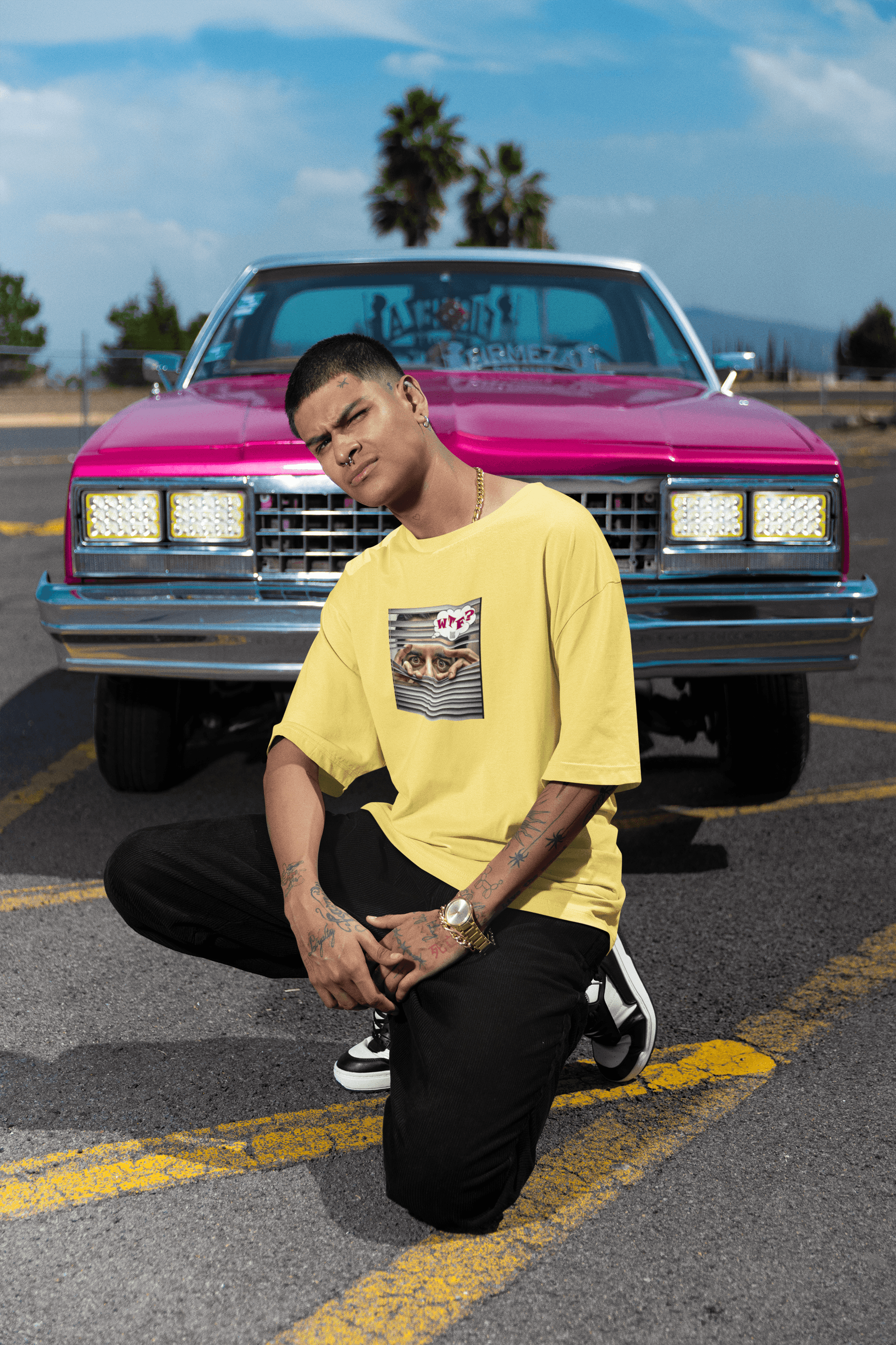 WTF activist t-shirt Hispanic male model posing in front of a pink car outdoors.