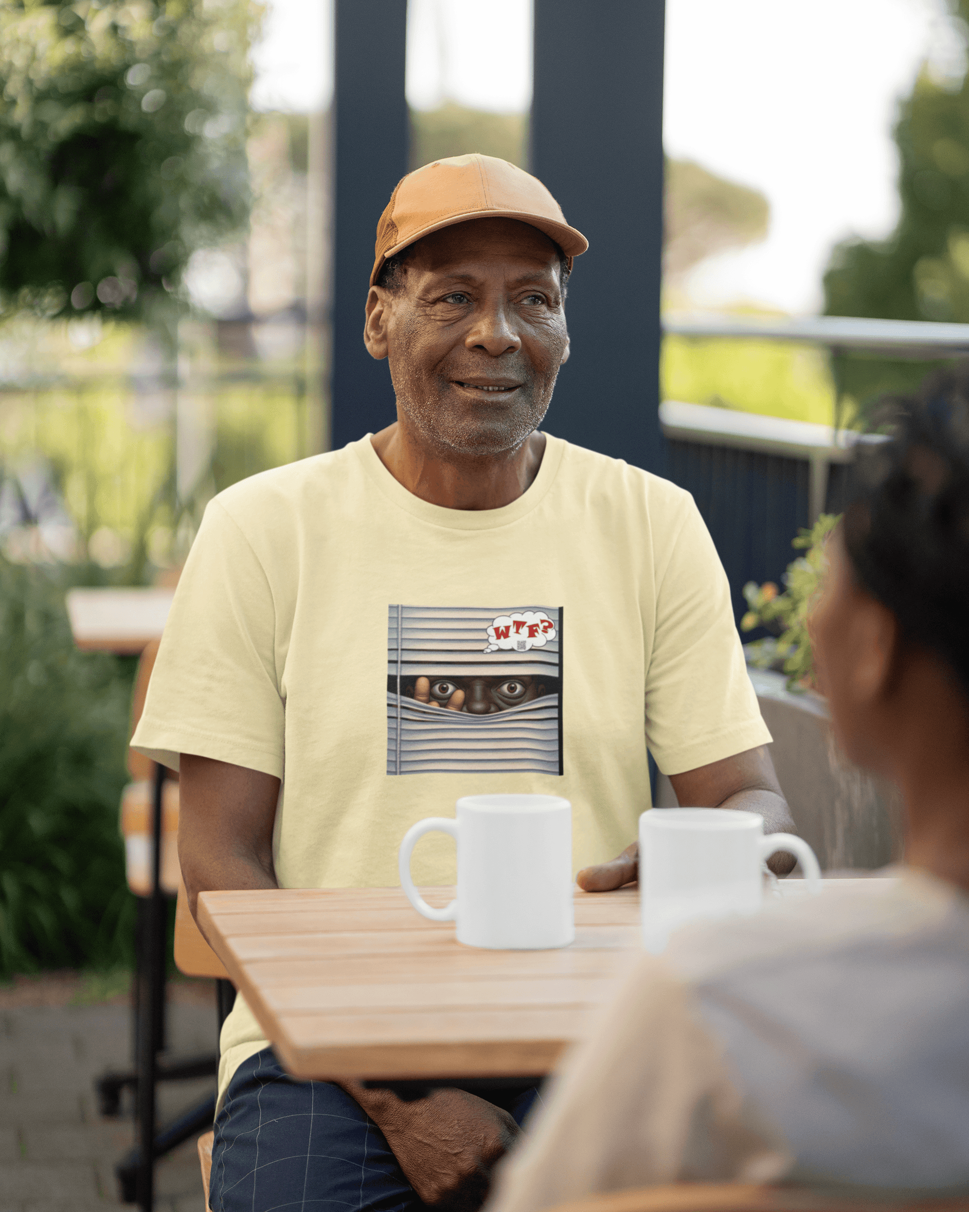 WTF Activist T-Shirt - Black Male Model Designed by jthomascrowne worn by an older man at a cafe.