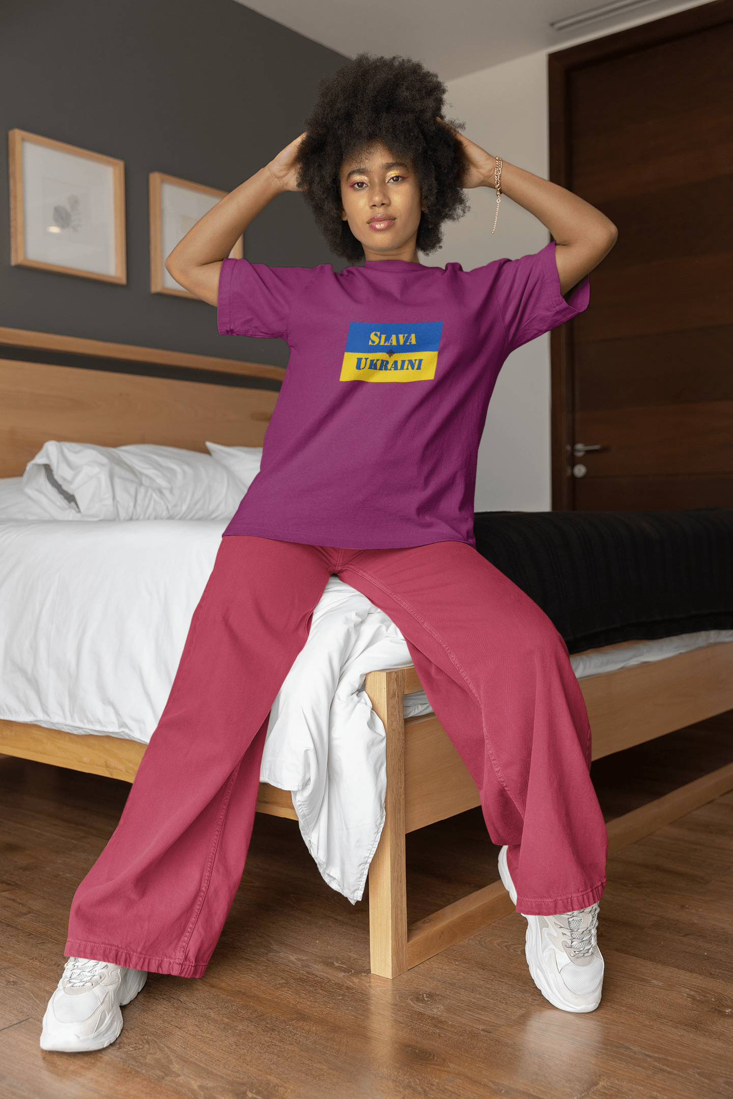 Slava Ukraini Tee Shirt worn by a model in a stylish bedroom setting, showcasing support for Ukraine.