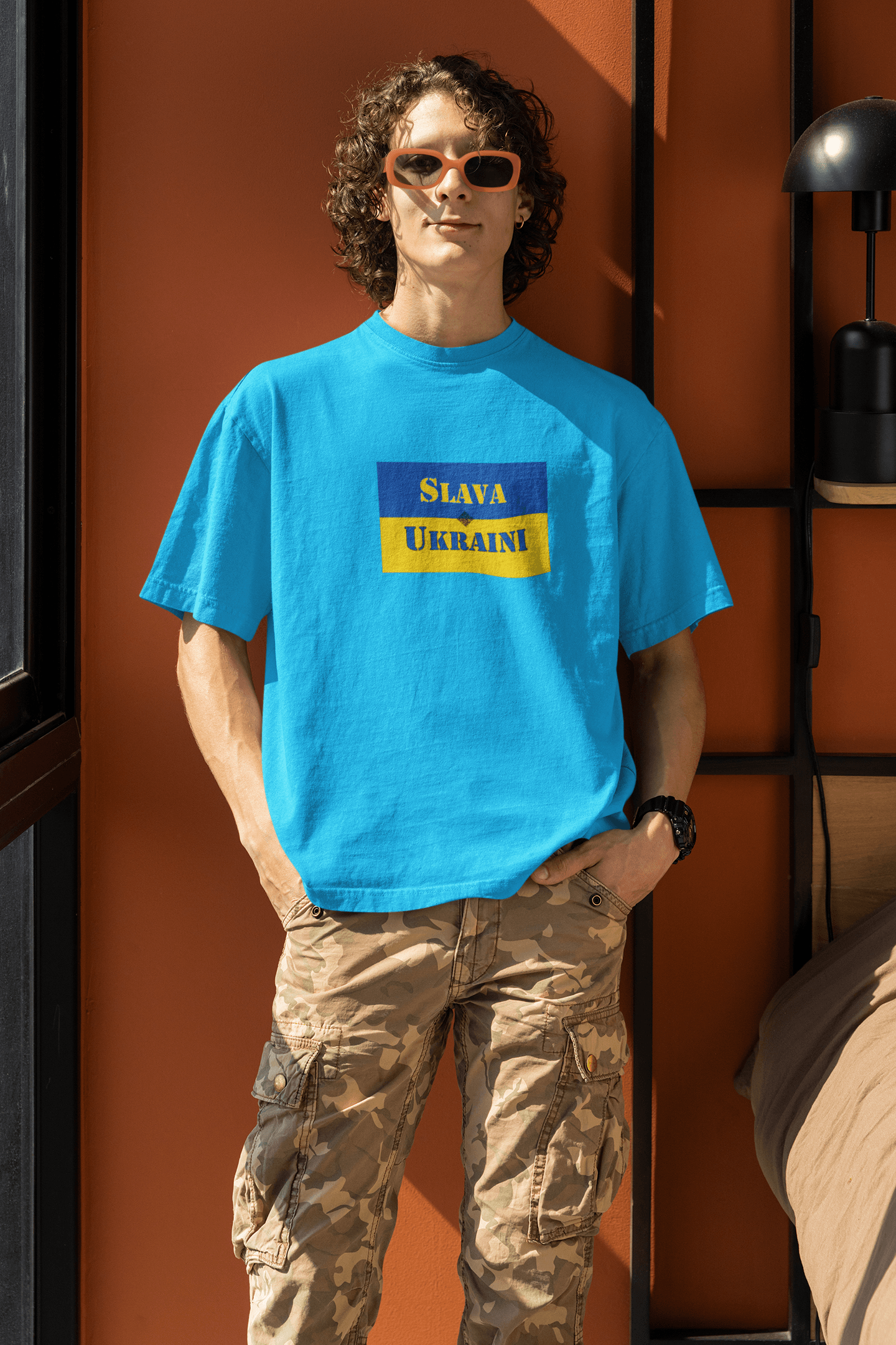 Young adult wearing a vibrant blue Slava Ukraini Tee Shirt, showcasing support for Ukraine's resilience.