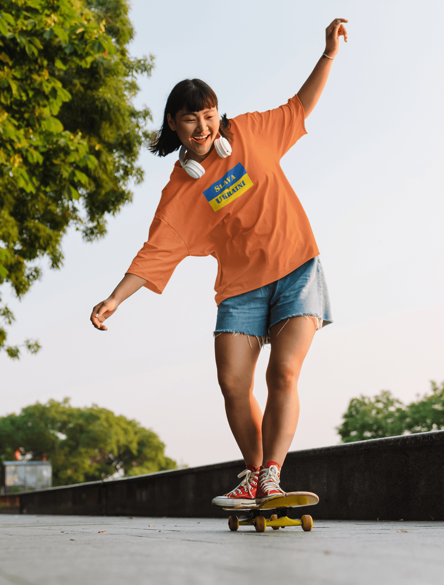 Person skateboarding in a Slava Ukraini Tee Shirt, showcasing solidarity with Ukraine while enjoying outdoor activity.