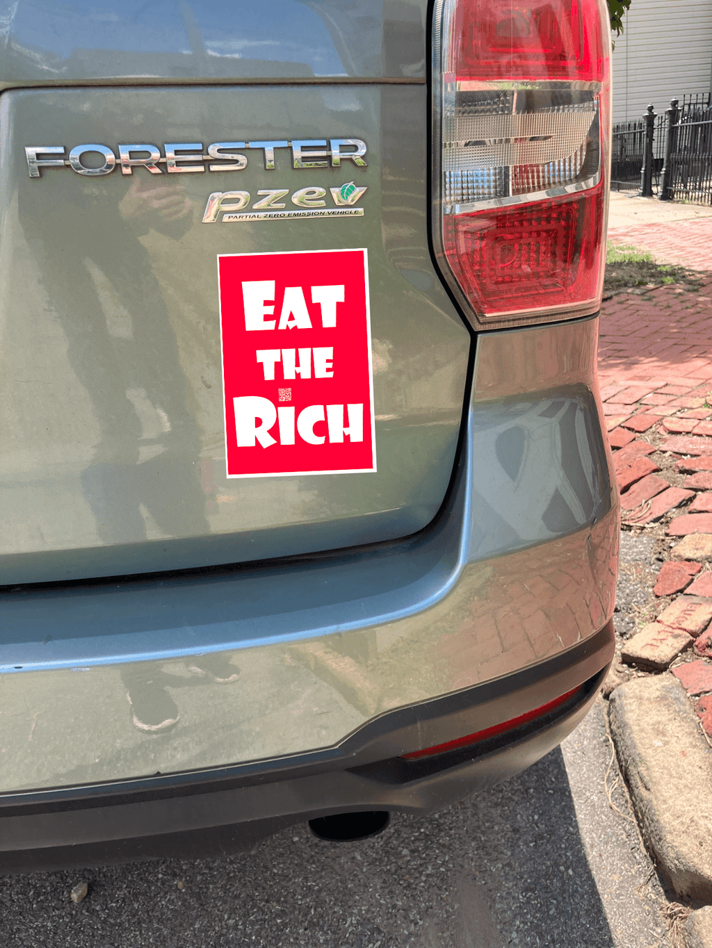 4" x 5" red magnet with white Eat the Rich lettering, on the back of a green car