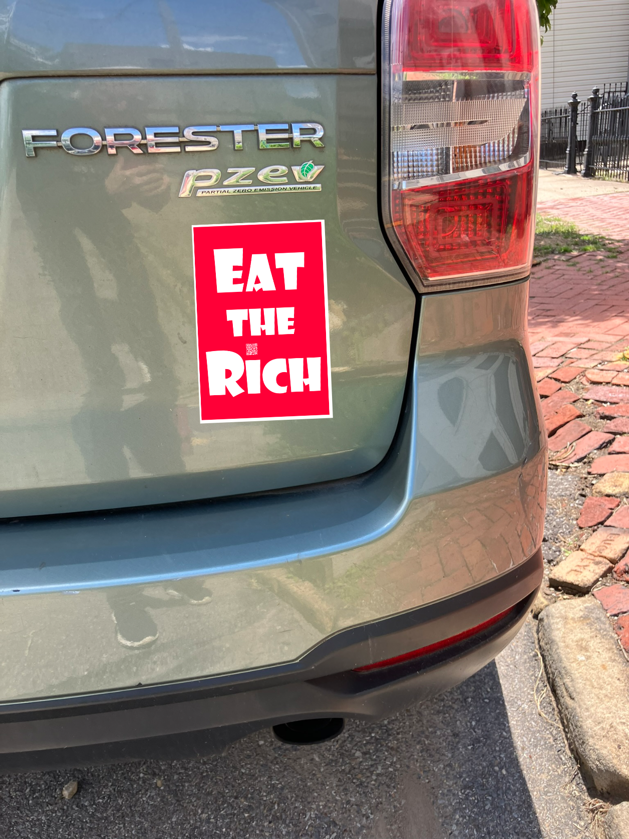 4" x 5" red magnet with white Eat the Rich lettering, on the back of a green car