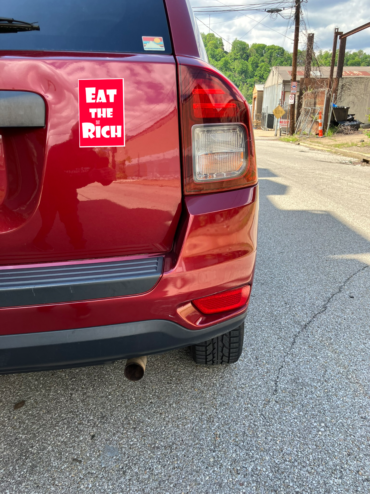 4" x 5" red magnet with white Eat the Rich lettering, on the back of a red car