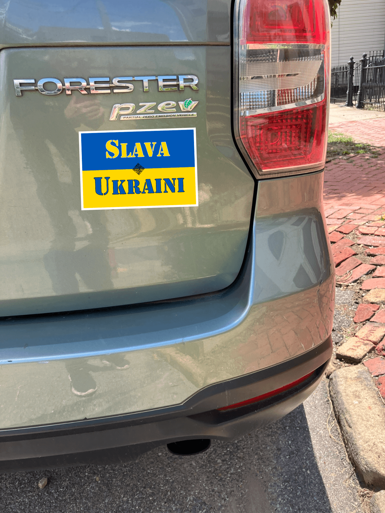 Car bumper showing Slava Ukraini magnet supporting Ukraine and democracy on a Subaru Forester.