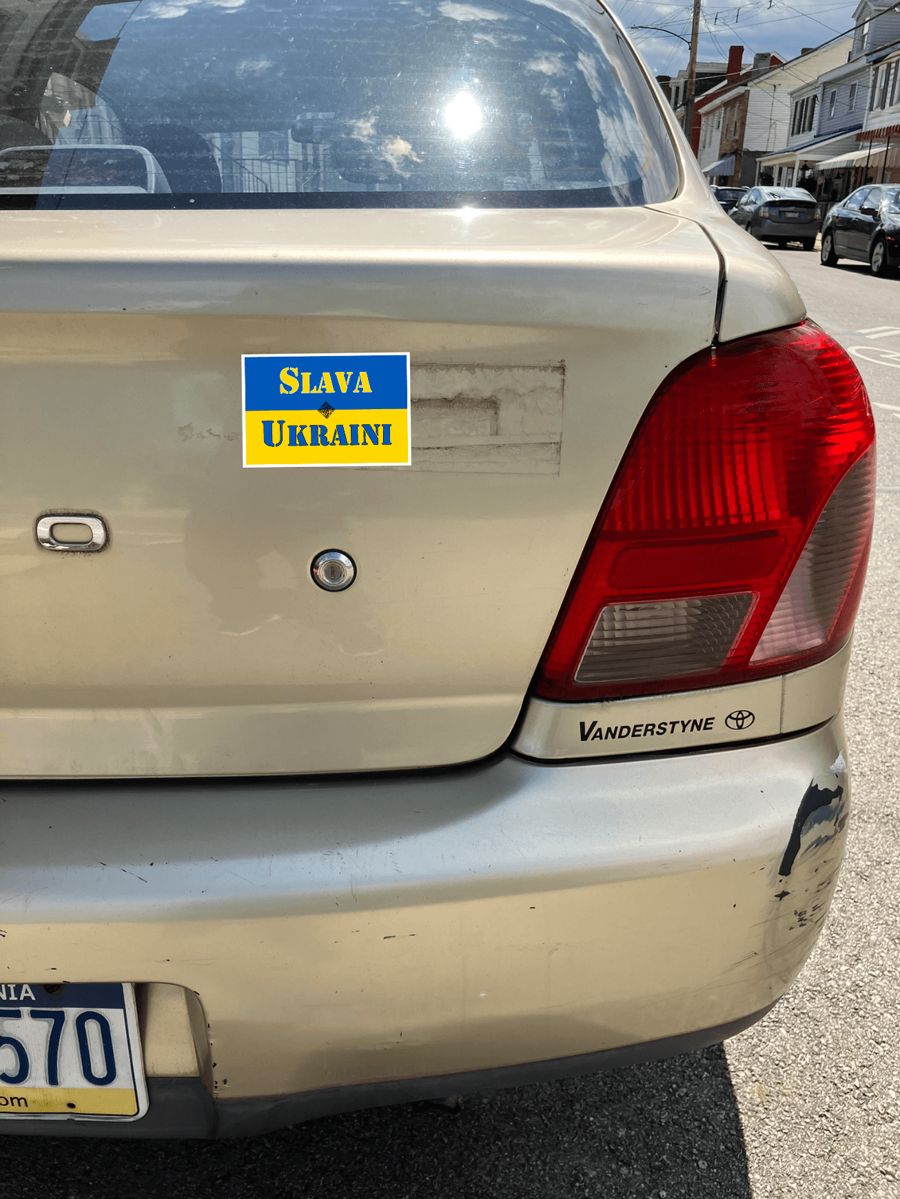 Silver car bumper with SLAVA UKRAINI magnet visible, showcasing support for Ukraine.