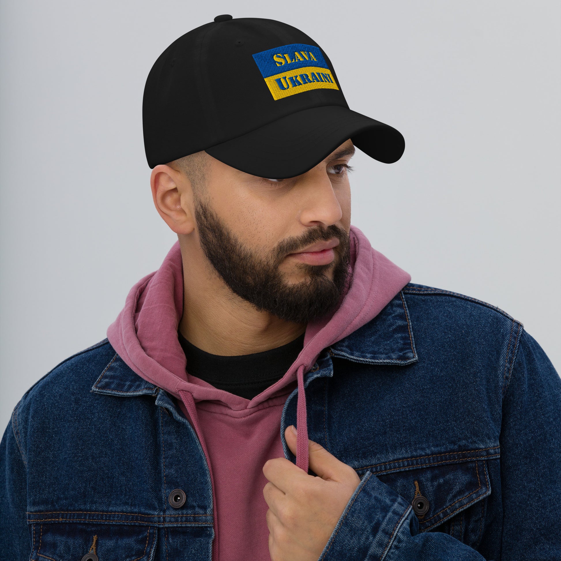 Model wearing Slava Ukraini Embroidered Dad Hat in black with colorful embroidery.